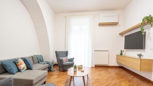 Ein modernes Wohnzimmer mit Sofa, Sessel und Couchtisch.
