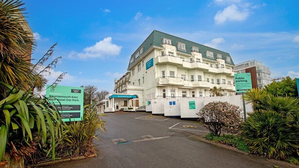 A building with a sign indicating public parking and a location ID. - Executive Double Room (Bournemouth)