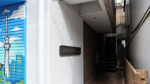 A narrow hallway with a textured wall, a sign reading "Dream Hotel," and a staircase leading to an upper level. - Dream Terrace One Casa Dali (Tokyo)