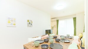 A dining area with a wooden table set for four, surrounded by chairs. - Zenith Nakano Shinbashi (Tokyo)