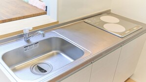 A kitchen with a stainless steel sink, a built-in scale, and a wooden countertop. - Zenith Nakano Shinbashi (Tokyo)