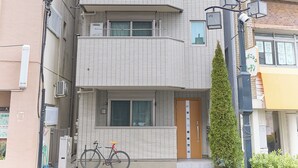 A multi-story building with balconies, a bicycle parked in front, and a small tree. - Zenith Nakano Shinbashi (Tokyo)