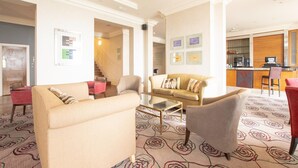 A hotel lobby with a sofa, armchairs, a coffee table, and a kitchen area in the background. - Standard family room for 4(2A+2C) (Bournemouth)