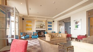 A spacious living room with a fireplace, comfortable seating, and a patterned carpet. - Standard family room for 4(2A+2C) (Bournemouth)