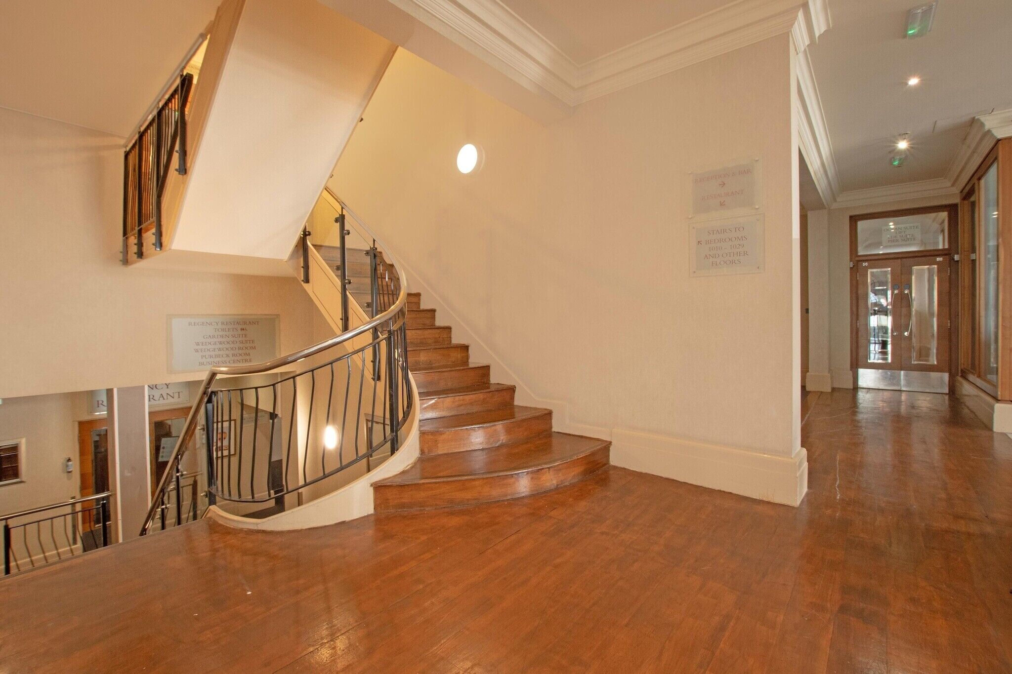 A wooden staircase with a metal railing leading to an upper floor.