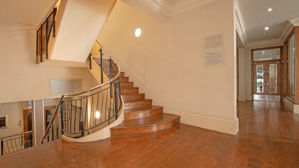 A wooden staircase with a metal railing leading to an upper floor. - Standard family room for 4(2A+2C) (Bournemouth)