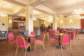 A hotel dining area with multiple tables and chairs, a patterned carpet, and chandeliers. - Standard family room for 4(2A+2C) (Bournemouth)