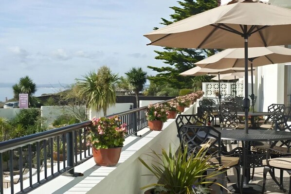 A terrace with outdoor seating, potted plants, and a view of the sea. - Superior Feature w/ View (Bournemouth)