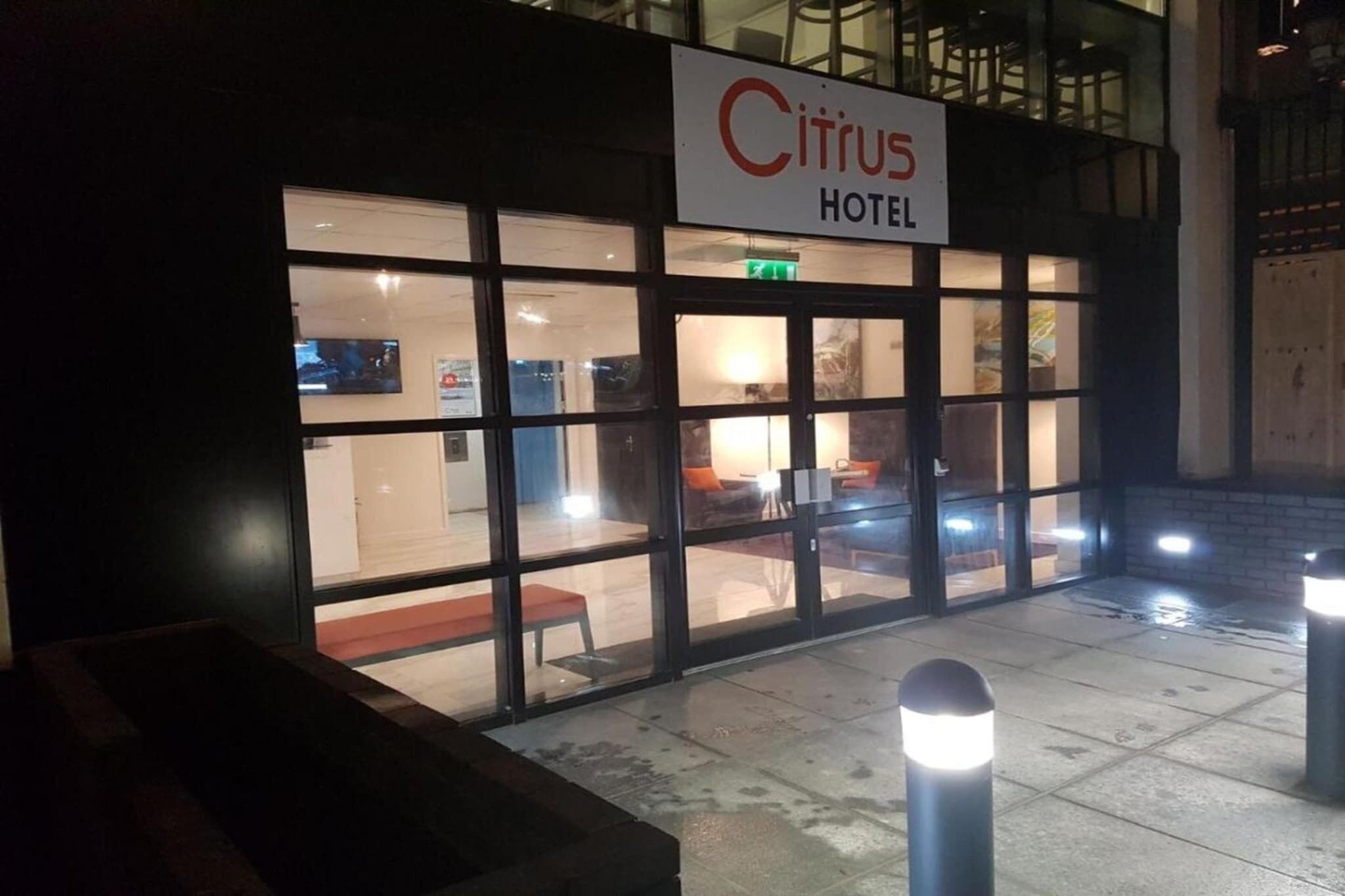 The exterior of the Citrus Hotel with a clear entrance, a visible seating area outside, and a signboard with the hotel's name.