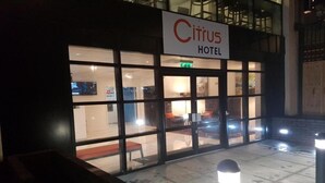 The exterior of the Citrus Hotel with a clear entrance, a visible seating area outside, and a signboard above the entrance.