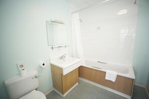 A bathroom with a toilet, sink, and bathtub. - Standard Triple Room (Cardiff)