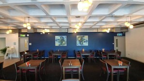 A restaurant with multiple tables and chairs, ceiling lights, and two paintings on the wall. - Cardiff Bute Terrace Hotel - Standard Triple Room (Cardiff)