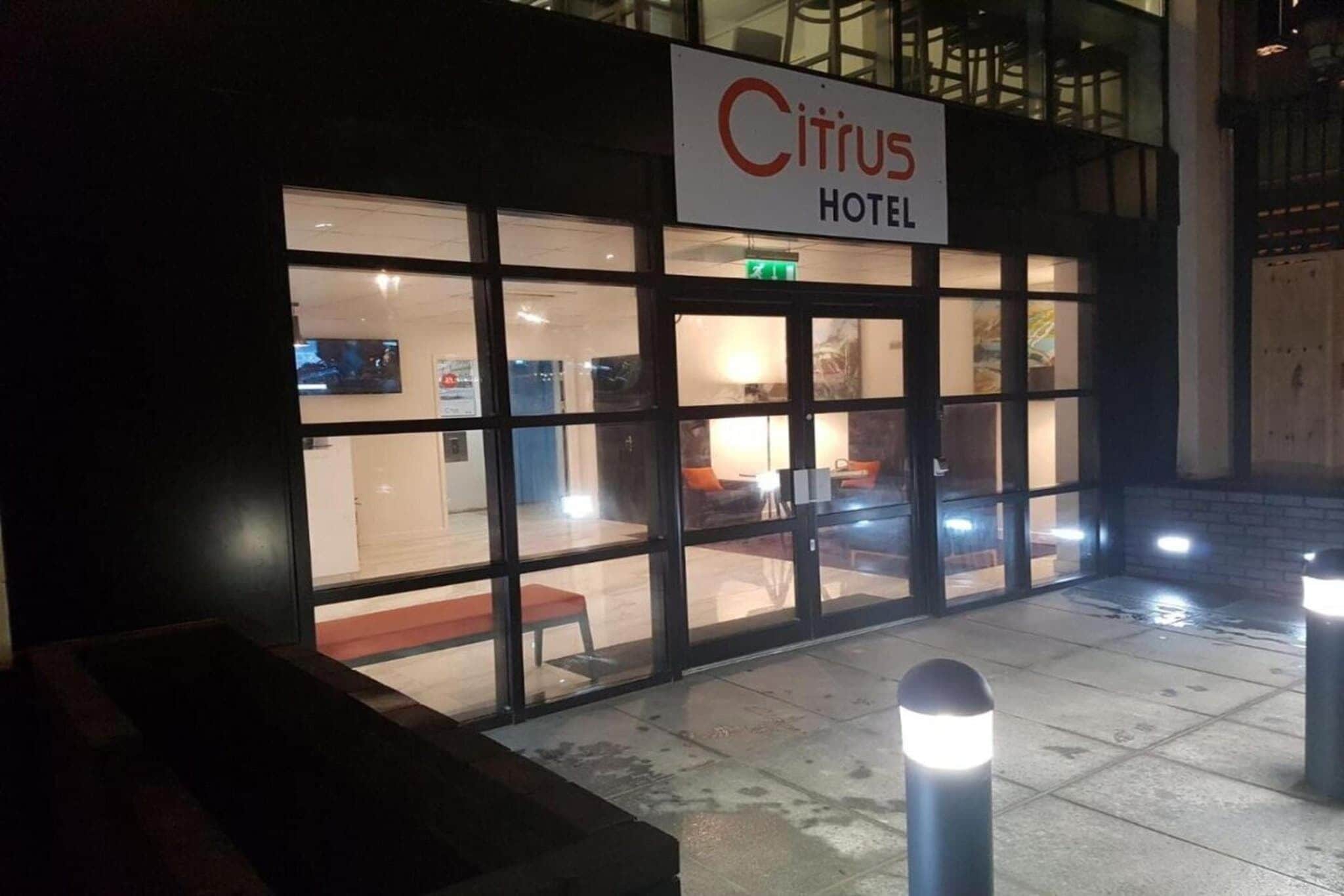 The exterior of the Citrus Hotel with a clear entrance, a visible seating area outside, and a signboard above the entrance.
