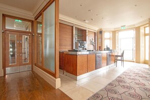 Un hall d’hôtel comprenant un comptoir d’accueil, une machine à café et un espace salon.