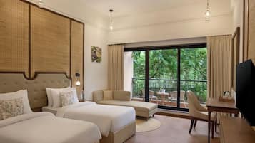 A hotel room with two beds, a sofa, a dining table, and a TV.