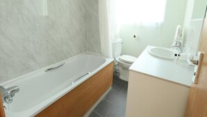 A bathroom with a bathtub, toilet, and sink. - Deluxe Double Room with View (Cardiff)