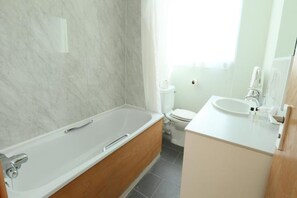 Une salle de bain avec une baignoire, des toilettes et un lavabo.