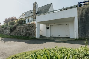 A modern house with a white exterior, a stone wall, and a garage door. - Holiday home with sea view, Le Conquet (Le Conquet)