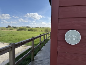 A wooden deck leading to a building with a sign reading 'LUNA'S LODGE.' - A luxury 2 bed lakeside lodge that sleeps 4 guests  in 2 bedrooms (Filey)
