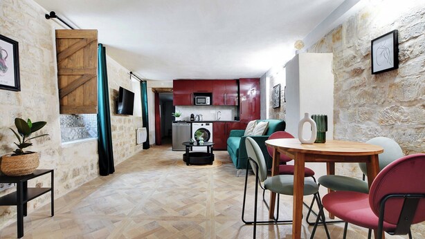 Un espacio habitable compacto con cocina, una mesa de comedor y sillas, y un sofá.