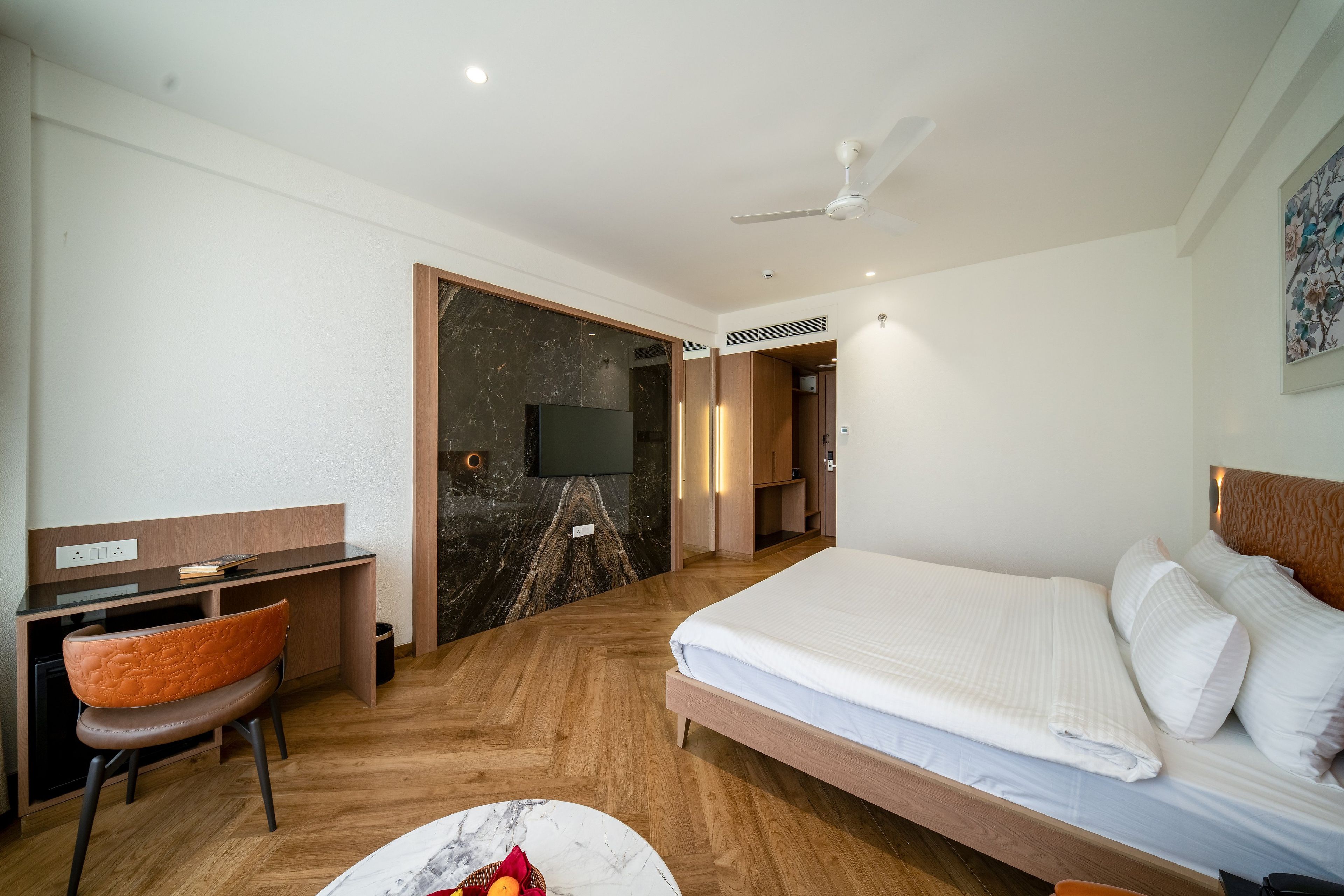 Una habitación de hotel con cama, escritorio, silla y televisión.