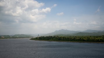 A river with a distant mountain range and a person standing on the bank.