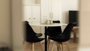 A dining area with a round table, black chairs, and a cabinet in the background. - Vacation apartment for couples also suitable for dogs (Staudach-Egerndach)