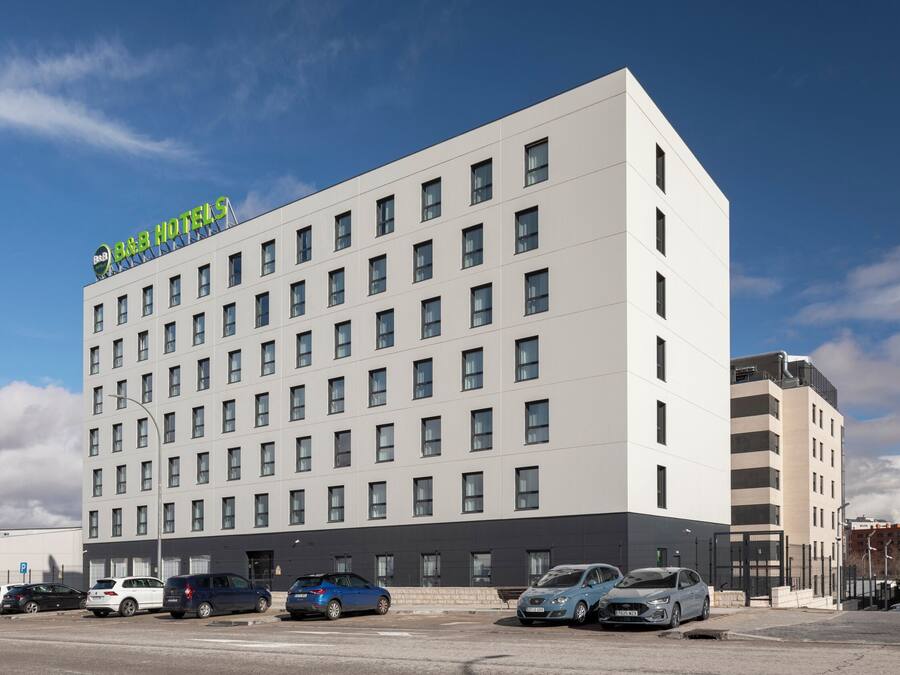 Ein mehrgeschossiges Hotel mit modernem Design, das ein markantes Schild oben trägt.