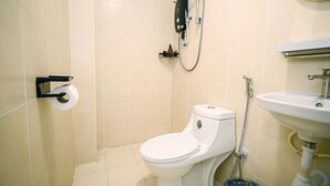Un baño pequeño con inodoro, ducha y lavamanos.