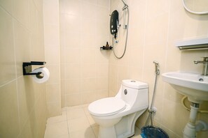 Un baño pequeño con inodoro, ducha y lavamanos.