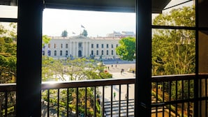 Una vista di un edificio dall'architettura classica, con uno spazio aperto centrale e verde circostante.