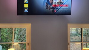 Seinälle asennettu televisio, jonka näytöllä näkyy Netflix-profiili ja elokuvan juliste.