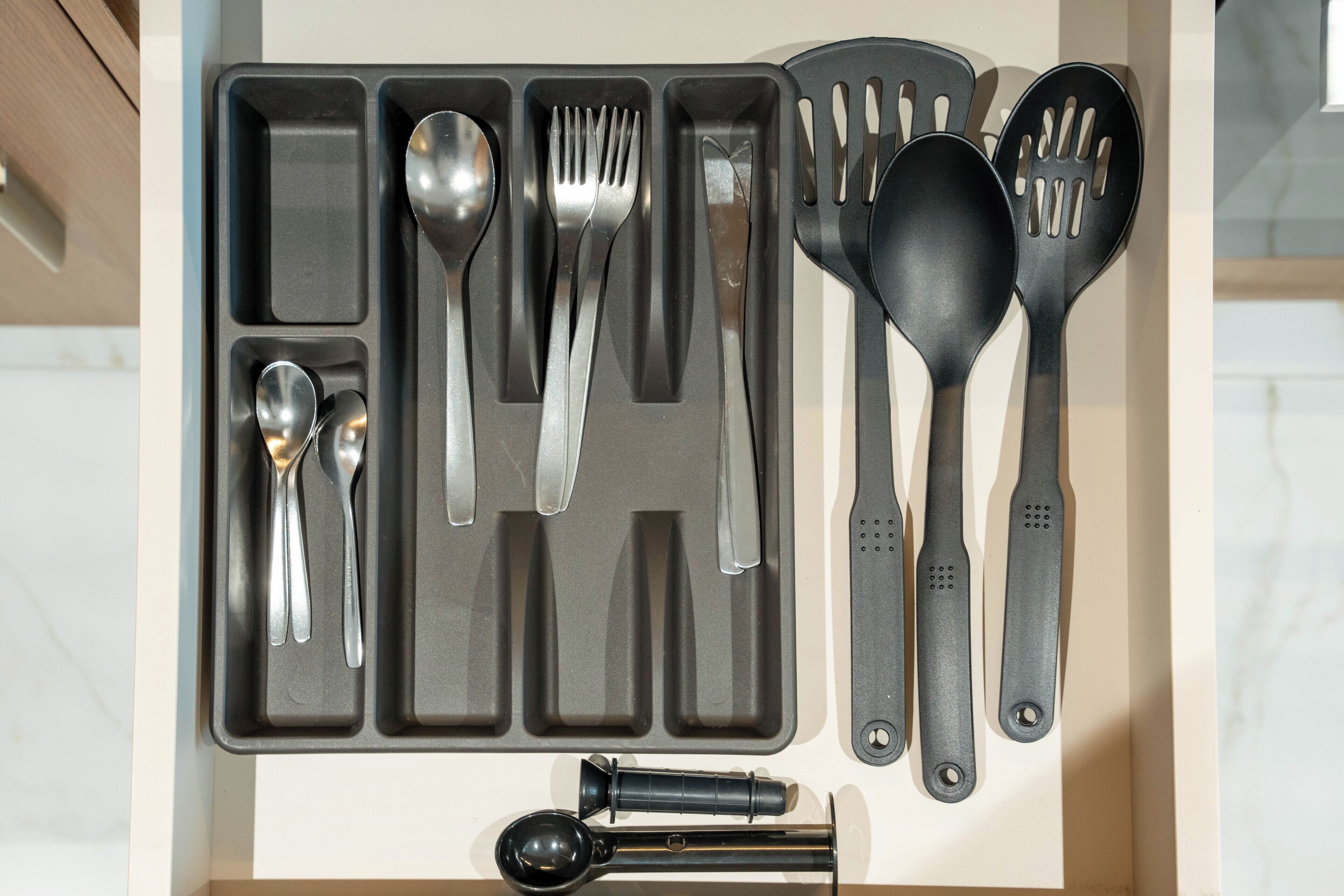 Un tiroir de cuisine contenant divers ustensiles, notamment des cuillères, des fourchettes et des spatules.