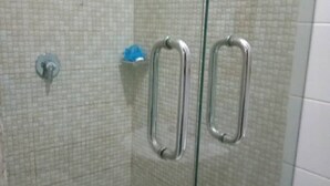 A shower area with two pull handles and the word "PULL" written on the wall. - Henods Luxury  Suites (Lagos)