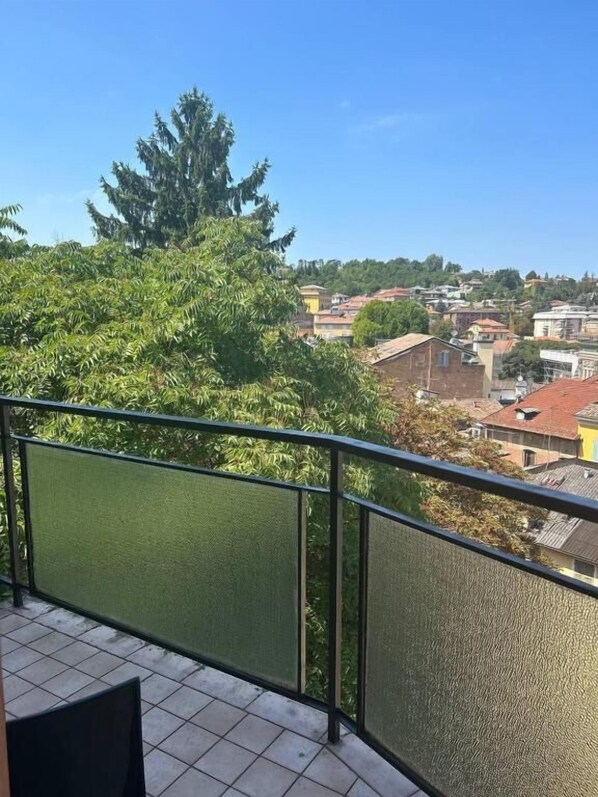 A balcony with a view of a residential area, including houses and trees. - Hotel Amica (Salsomaggiore Terme)