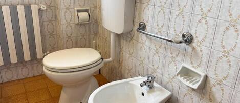 A bathroom with a toilet, bidet, and sink.