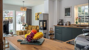 A modern kitchen with a wooden island, a built-in stove, and a large window. - Modern living close to the beach for up to 6 people (Dierhagen)