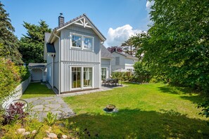 A two-story house with a large front yard, a stone pathway, and a dining area. - Modern living close to the beach for up to 6 people (Dierhagen)