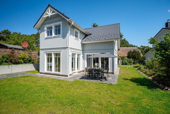 A two-story house with a patio, a dining area, and a garage. - Modern living close to the beach for up to 6 people (Dierhagen)