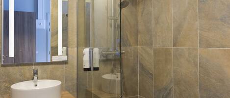 A bathroom with a white sink, a mirror, and a shower.