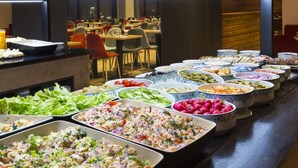 Un buffet con diversi piatti, tra cui insalate, frutta e verdura.