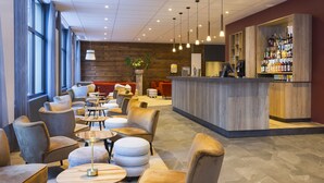 Un'area lounge moderna con posti a sedere, un bar e un'ampia finestra.