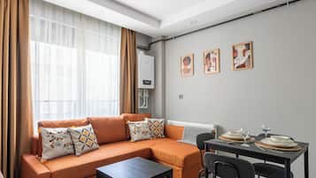 Appartement Deluxe, 1 chambre, cuisine, rez-de-chaussée | Coin séjour | Télévision de 80 cm avec chaßnes par cùble, Netflix