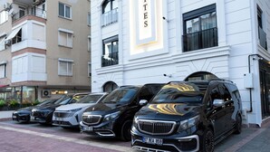 Eine Reihe luxuriöser schwarzer SUVs vor einem Gebäude mit der Aufschrift "HITES".