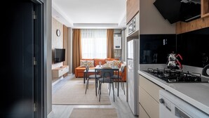 Eine moderne Küche mit Gasherd, Mikrowelle und Backofen. Ein Essbereich mit Tisch und Stühlen sowie eine Sitzecke mit Kissen vorhanden.