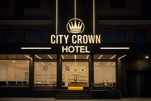 El exterior del Hotel City Crown, con un llamativo logotipo con forma de corona sobre el nombre.