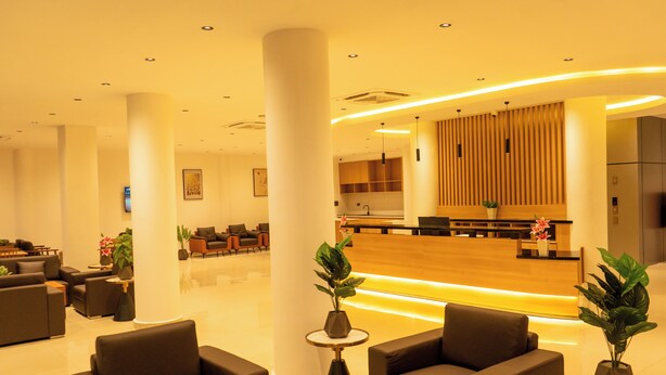 A modern lobby with a reception desk, seating area, and large columns. - City Crown Hotel (Dar es Salaam)