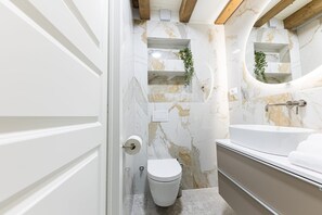 A bathroom with a toilet, a sink, and marble walls. - Casa di Pietra Stone House (Kaštel Lukšić)