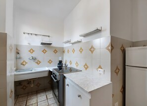 Eine kleine Küche mit Spüle, Herd und Kühlschrank.