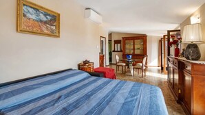 A bedroom with a bed, a desk, a chair, and a dining table with chairs. - Apartment 'Solarolo Cristina' with Lake View, Wi-Fi and Air Conditioning (Solarolo)